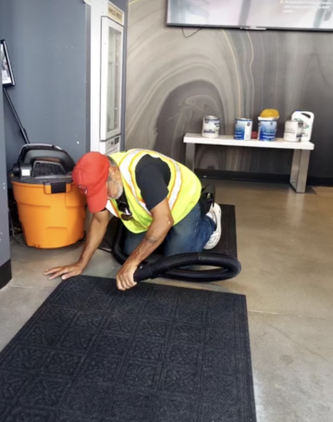 Worker cleaning floor mats